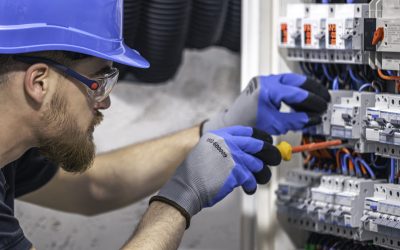 male electrician working in a switchboard with fuses. male electrician working in a switchboard with fuses.